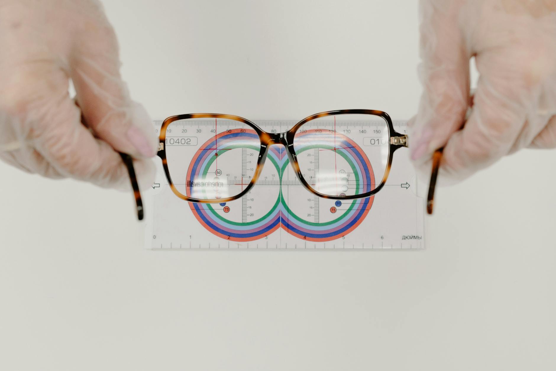 crop ophthalmologist measuring eyeglasses with lens ruler